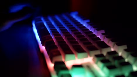 Side-view-of-male-hands-working-on-keyboard-with-glowing-keys