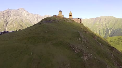 aérea.-Gergeti-iglesia-ortodoxa-alto-en-las-montañas,-Georgia