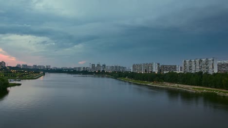 Cityscape-with-river-traffic-and-movement-of-the-clouds-at-dusk