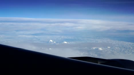 Flugzeug-Fenster-mit-Blick-auf-die-Wolken-vom-Beifahrersitz