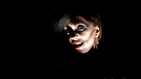 Halloween-party,-night,-frightening-portrait-of-a-woman-in-the-twilight,-in-the-rays-of-light.-woman-with-a-terrible-make-up-in-a-black-witch-costume