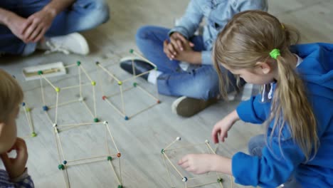 Chicas-haciendo-forma-3D-con-palitos-en-el-jardín-de-la-infancia-lección