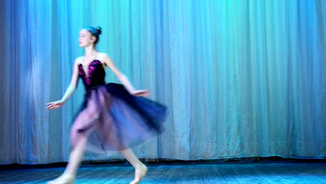 ballet-rehearsal,-on-the-stage-of-the-old-theater-hall.-Young-ballerina-in-lilac-black-dress-and-pointe-shoes,-dances-elegantly-certain-ballet-motion,-grand-jete-pat-de-chate