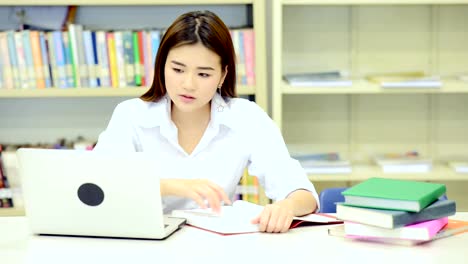 Studie-schwer-in-der-Bibliothek.-Junge-Chinesin-Studium-hart-an-der-Bibliothek.