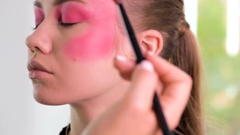 Mode-Modell-immer-schussbereit.-Make-up-Artist-Hände-gelten-Kosmetik-auf-Modellfläche-in-einem-Zeitraffer-Bewegung