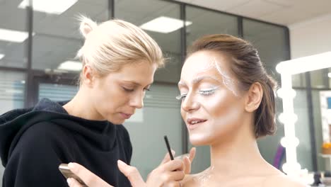 Make-up-Artist-zieht-Körperkunst-auf-dem-Modell.-Vorbereitung-für-eine-Foto-session