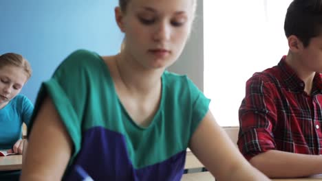 group-of-students-with-notebooks-writing-test-at-school