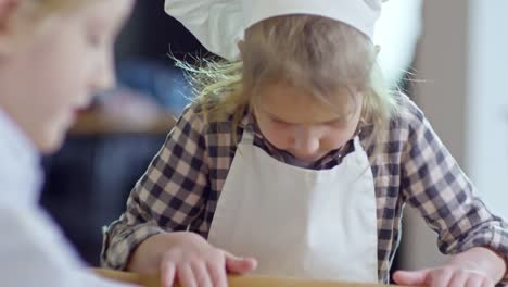 Girl-Rolling-Out-Dough-with-Brother