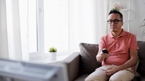 hombre-con-control-remoto-en-casa-viendo-la-televisión