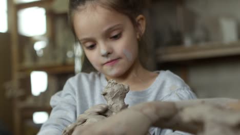 Entzückende-kleine-Mädchen-modellieren-mit-Ton