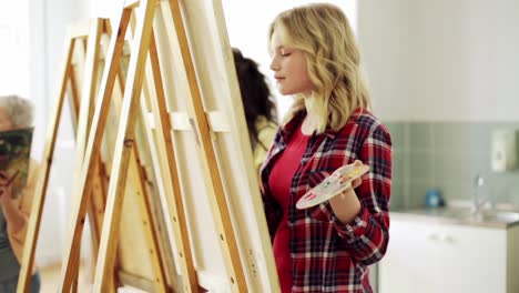 students-with-easels-painting-at-art-school