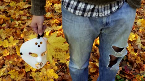 Hombre-con-scary-Halloween-Máscara-y-hojas-de-otoño