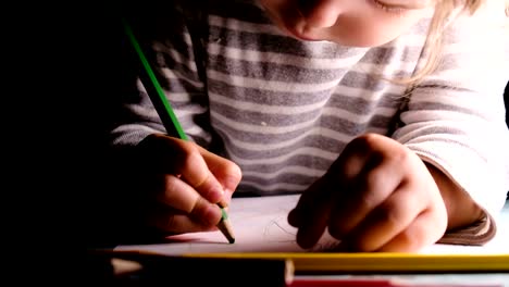 Little-baby-girl-draws-green-pencil-on-a-sheet-of-paper-close-up