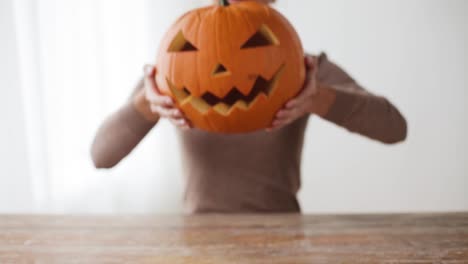 Nahaufnahme-von-Frau-mit-Halloween-Kürbis-zu-Hause