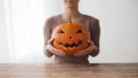 Nahaufnahme-von-Frau-mit-Halloween-Kürbis-zu-Hause