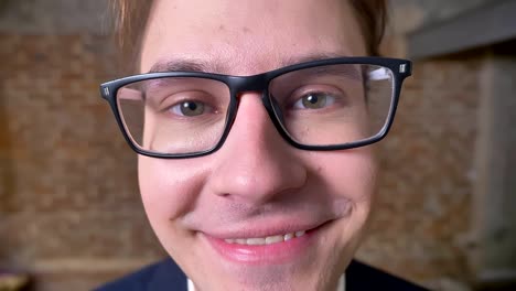 Close-up-happy-smiling-face-of-caucasian-man-in-glasses,-direct-look-and-pleased-person,-indoor