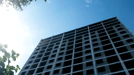 Multi-storey-under-construction-building-and-construction-crane-on-clear-sky-background.