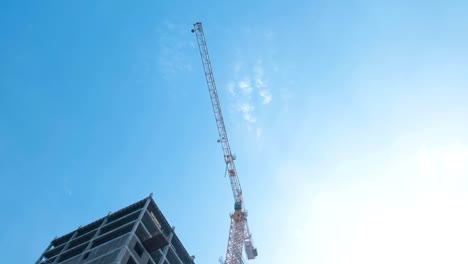 Multi-storey-under-construction-building-and-construction-crane-on-the-background-of-clear-sky.