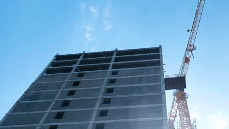 Multi-storey-under-construction-building-and-construction-crane-on-the-background-of-clear-sky.