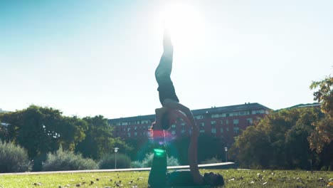 Schönes-paar-praktizieren-Acro-Yoga-am-Morgen