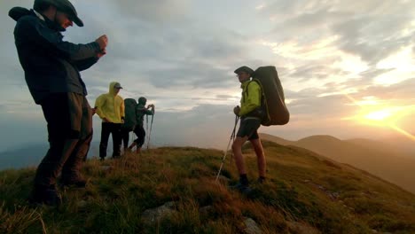 los-excursionistas-toman-fotos-en-un-teléfono-inteligente-al-atardecer-en-la-cima-de-la-montaña