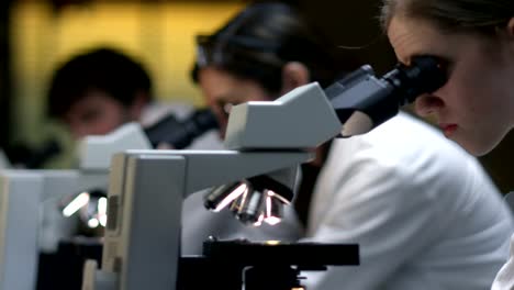 College-Students-in-a-lab-look-through-a-microscope-during-their-class