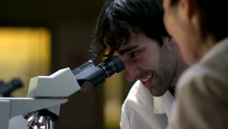 College-Students-in-a-lab-look-through-a-microscope-during-their-experiments