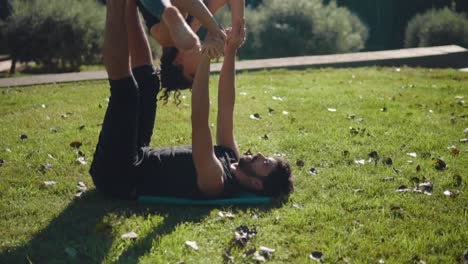 Schönes-paar-praktizieren-Acro-Yoga-am-Morgen