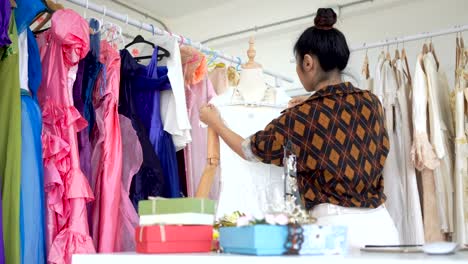 Las-mujeres-asiáticas,-los-trabajadores-están-midiendo-la-longitud-de-la-camisa-que-se-cose-en-la-tienda-de-la-tela.