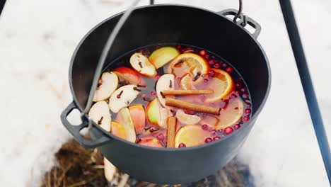 Kochen-Glühwein-am-Lagerfeuer-in-den-Winterwald.