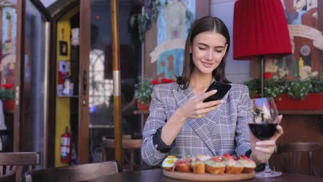 Schöne-Frau,-die-die-Nahrung-Fotos-auf-dem-Handy-im-Restaurant