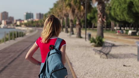 Tourist-girl-walks-on-the-seafront-of-the-city.-Italian-vacation