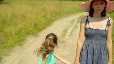 Mother-and-her-daughter-walking-along-a-rural-road