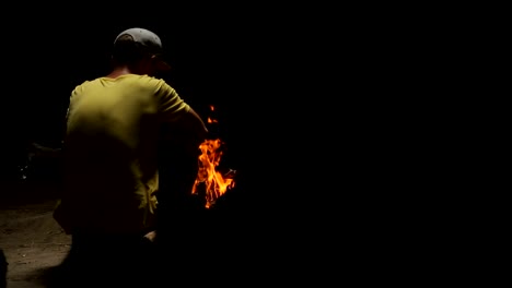 Young-man-sitting-by-campfire