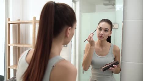 Makeup.-Woman-Applying-Eyeshadows-And-Looking-At-Mirror