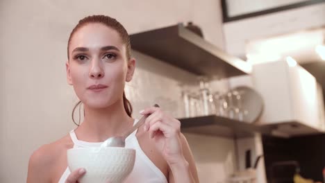 Beautiful-Woman-Eating-Food-From-Bowl-At-Kitchen-Closeup