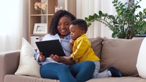 madre-usando-Tablet-PC-con-bebé-hijo-en-casa