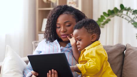 mother-using-tablet-pc-with-baby-son-at-home