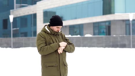 Junger-Mann-wartet-auf-jemanden-in-der-Winter-Stadt