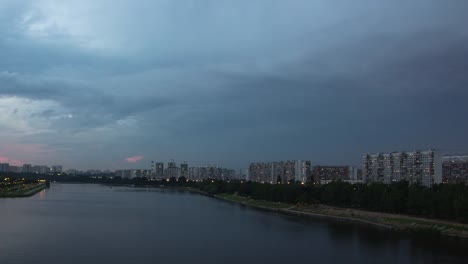 Cityscape-with-river-traffic-and-movement-of-the-clouds-at-dusk