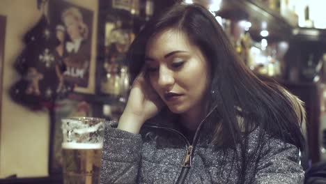 fascinating-and-depressed-woman-drinking-a-glass-of-beer-in-a-pub