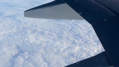 View-of-the-wing-of-an-airplane-in-flight-over-beautiful-air-clouds