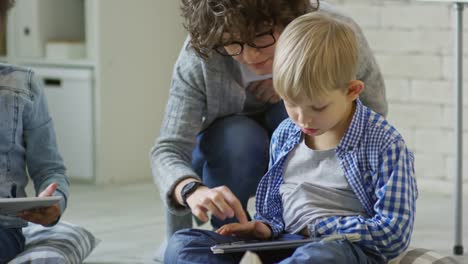 Female-Teacher-Helping-Kids-to-Use-Digital-Tablet