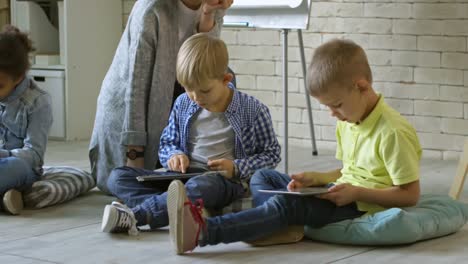 Kinder-lernen-digitale-Tablets-mit-Lehrerin