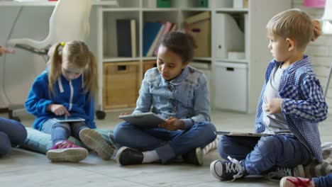 Niños-pequeños-aprender-tabletas-en-jardín-de-infancia