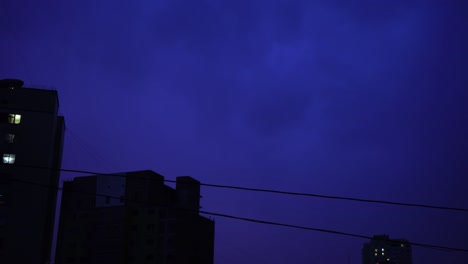 Relámpago-en-el-cielo-nocturno-de-la-ciudad,-un-brillante-destello-de-luz-en-las-nubes-en-la-lluvia,-una-tormenta-eléctrica