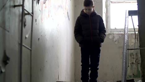 frightened-boy-walking-on-dilapidated-old-house