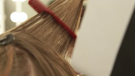 Hairdresser-combing-female-hair-during-haircutting-in-beauty-salon.-Close-up-woman-hairstyle-in-beauty-salon.-Hairdresser-working-with-woman-client