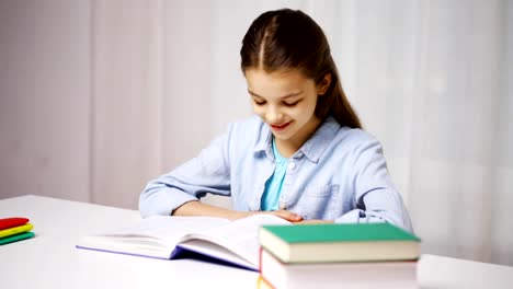 happy-school-girl-reading-book-or-textbook-at-home