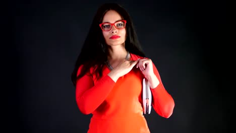 Retrato-de-mujer-sexy-morena-con-labios-rojos,-vestido-rojo-y-gafas-rojas-con-bolso-pequeño-blanco,-ella-danza-y-juguetonamente-se-mueve,-sexualmente-mirando-a-cámara,-posando-en-el-estudio